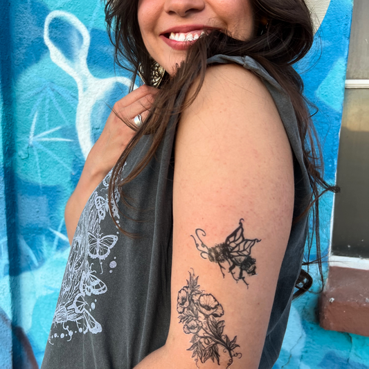 woman showing her arm with vibrant, black temporary tattoo of bumble bee