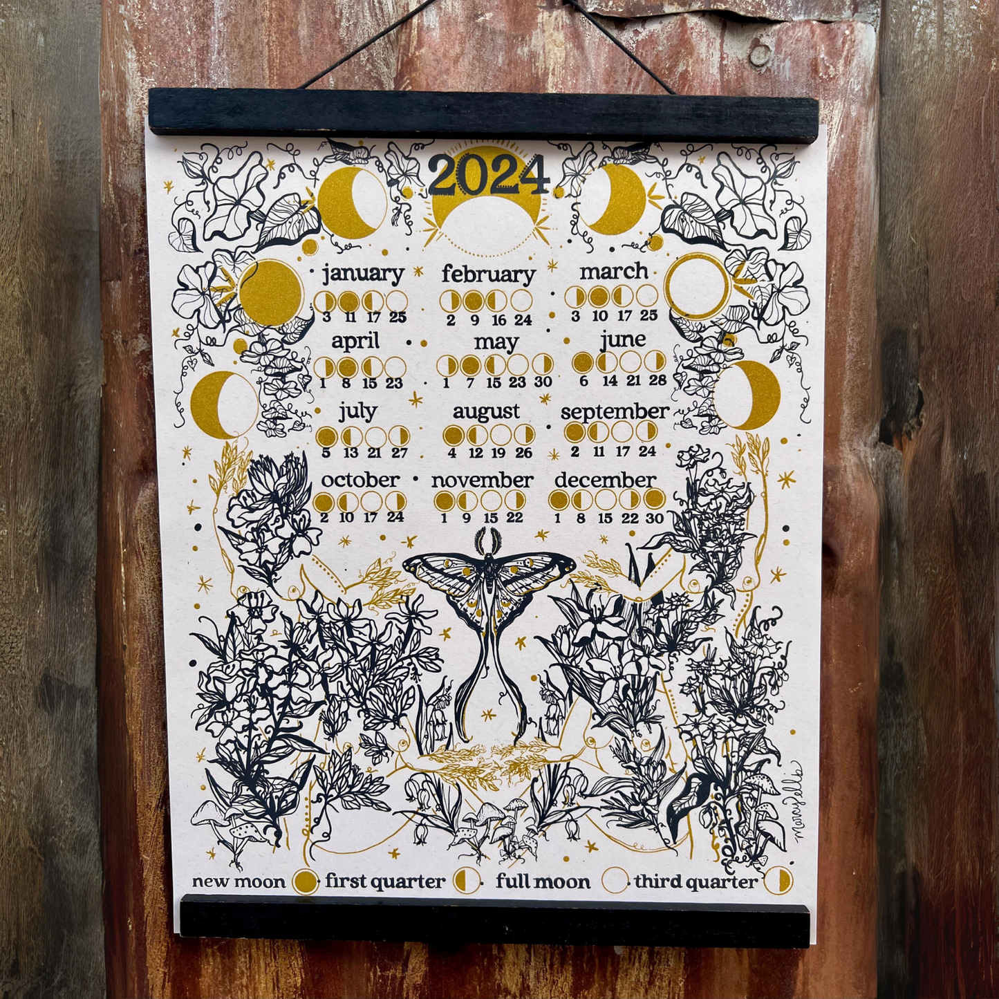 white 2024 moon phase calendar displayed on wall