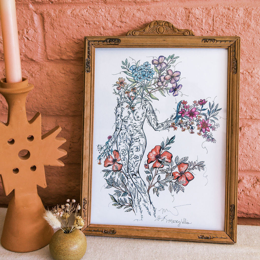 Framed botanical illustration on a textured surface with a pink brick wall background