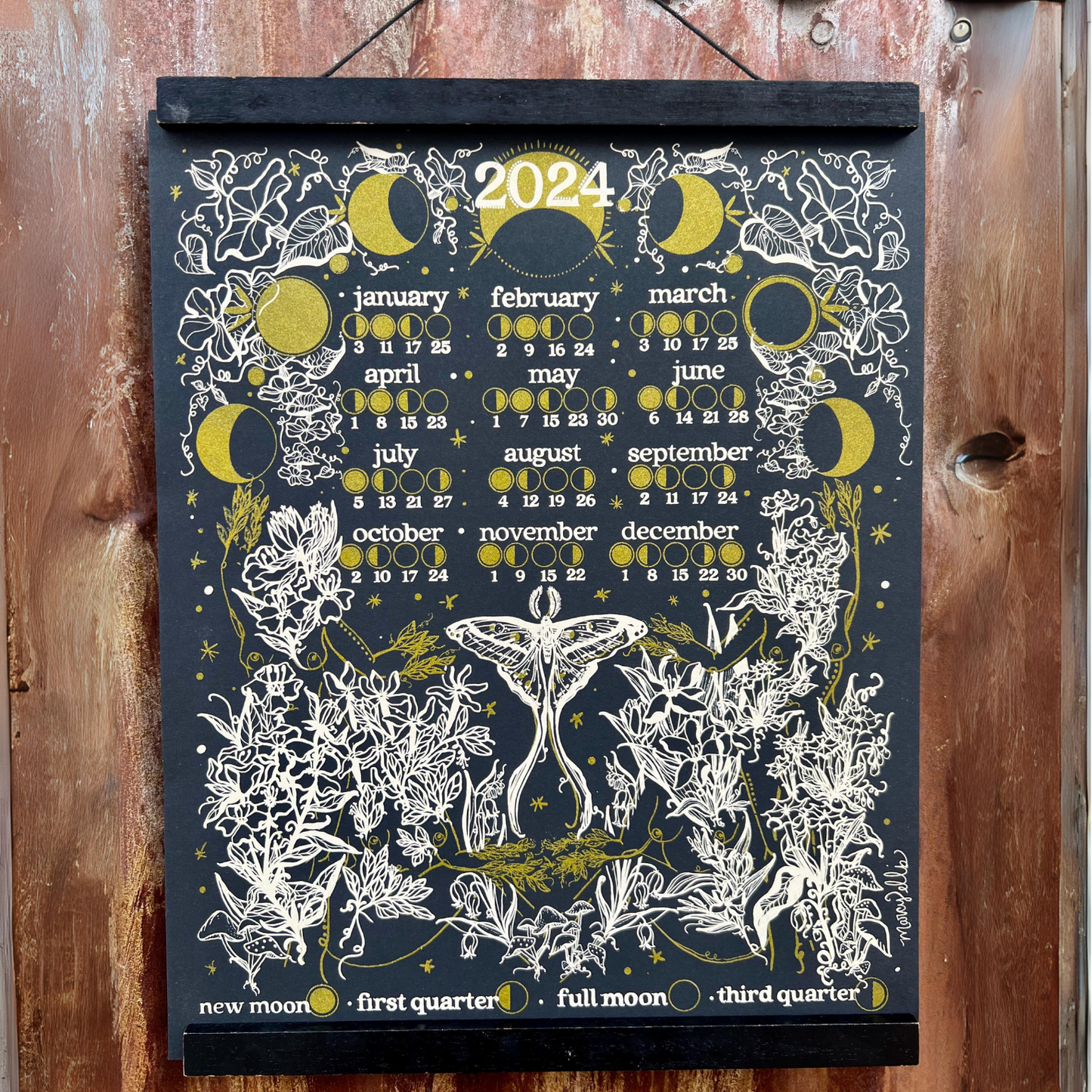 black 2024 moon phase calendar displayed on wall