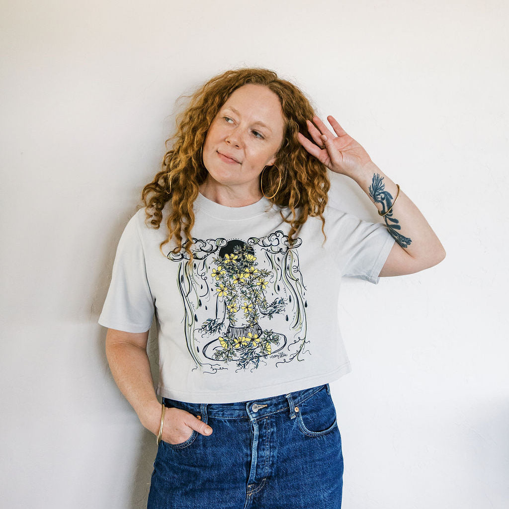 Marcy Ellis wearing monsoon caller screen printed crop tee with creosote flowers and desert rain clouds by marcy ellis
