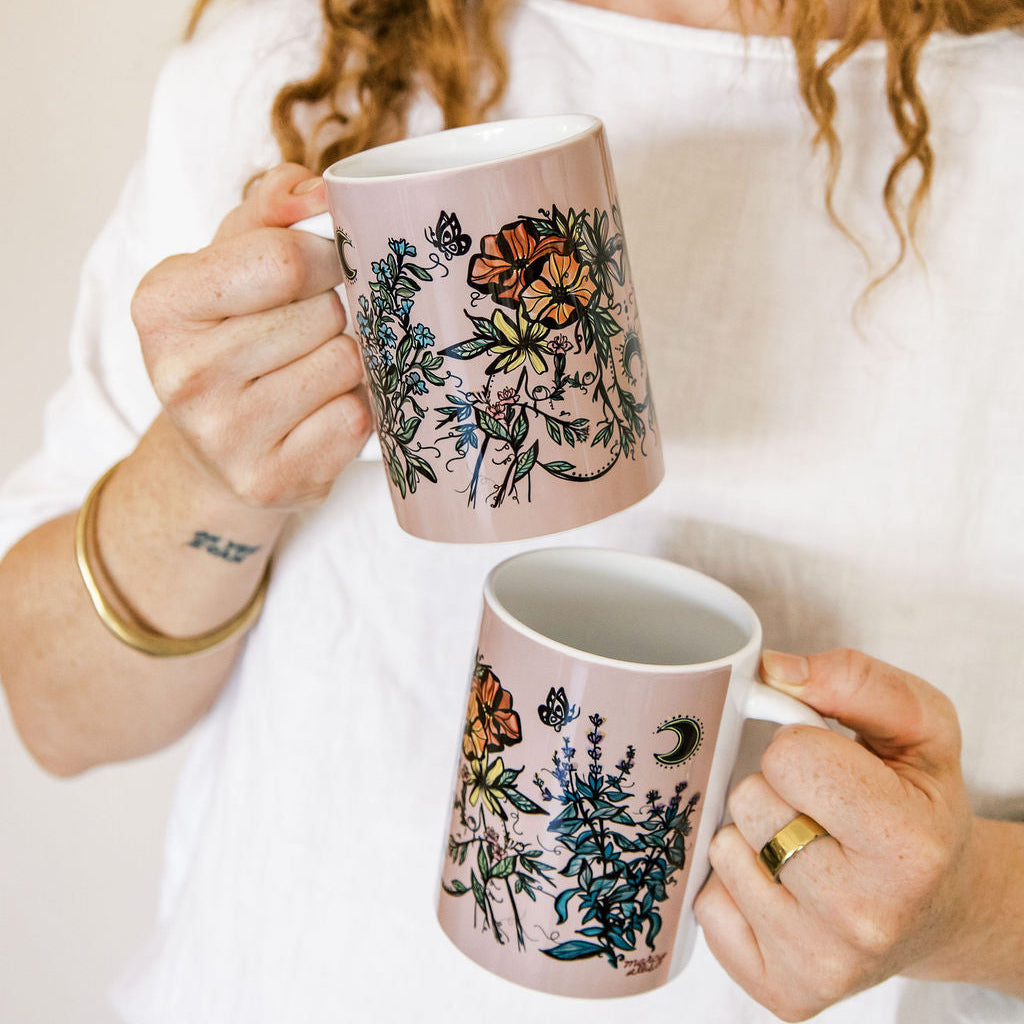 two botanical feminine bodies on a white and purple ceramic mug. 