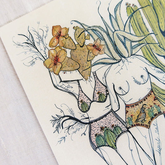 Watercolor art print of two feminine figures in swimsuits among desert cacti and flowers on a textured beige background