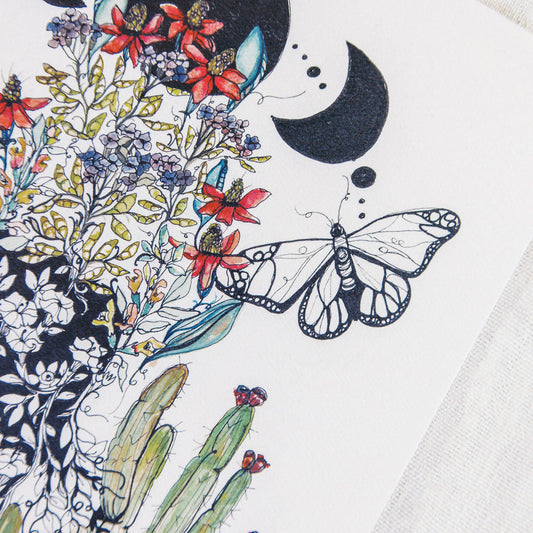 Details of an artistic art print of a female figure under lunar phase, surrounded by cacti, flowers, and butterflies on a textured beige background.