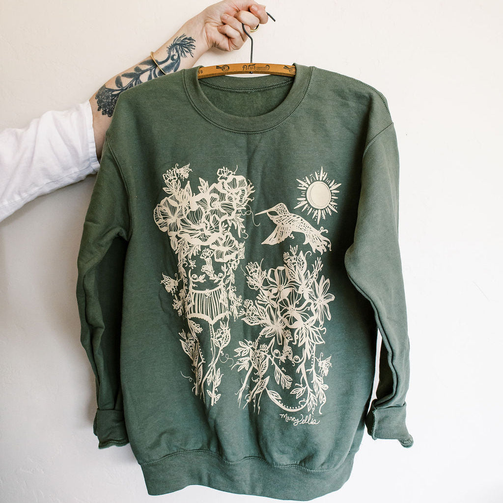 Green sweatshirt with floral design on a hanger against a white background