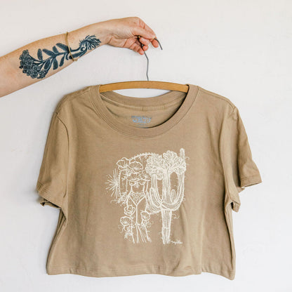 sand boxy crop tee hand screen printed with an ivory crested saguaro and botanical figure design by marcy ellis