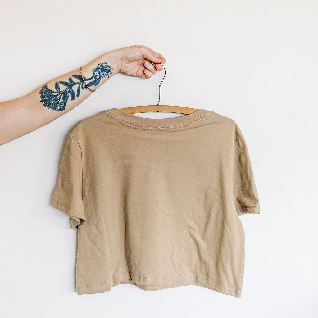 back of a sand boxy crop tee hand screen printed with an ivory crested saguaro and botanical figure design by marcy ellis
