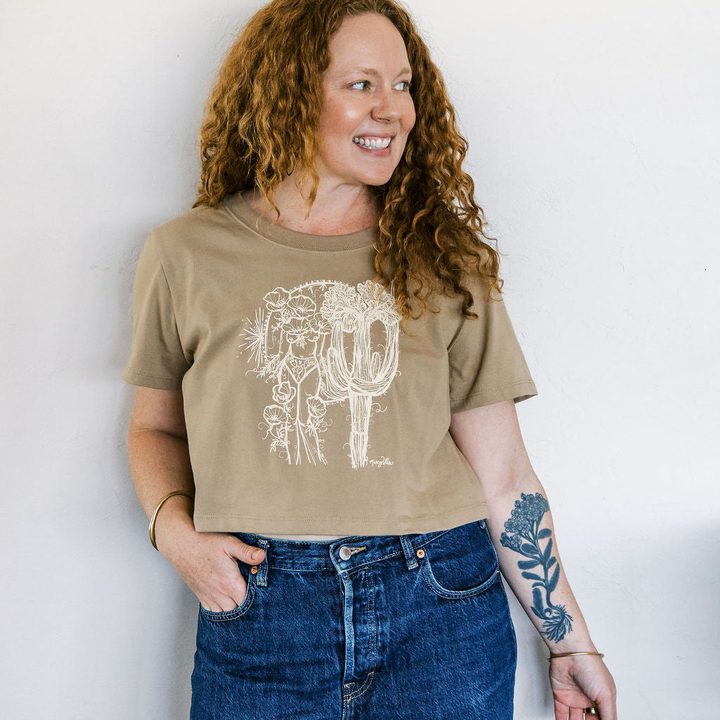 woman wearing a sand boxy crop tee hand screen printed with an ivory crested saguaro and botanical figure design by marcy ellis