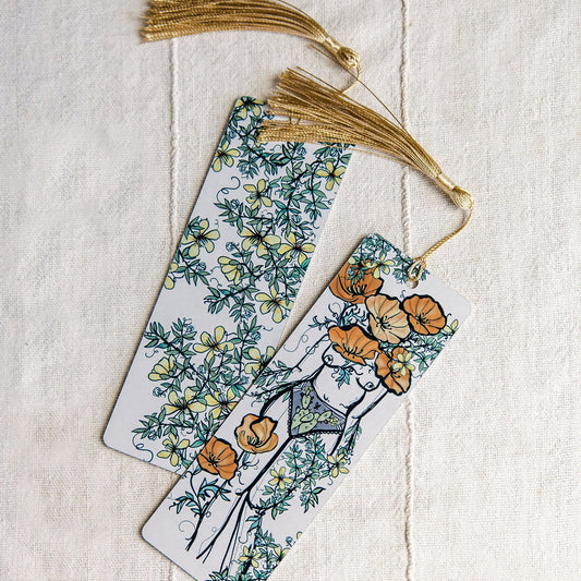 two metal bookmarks with desert poppy flowers and a botanical figure and creosote by Marcy Ellis. 
