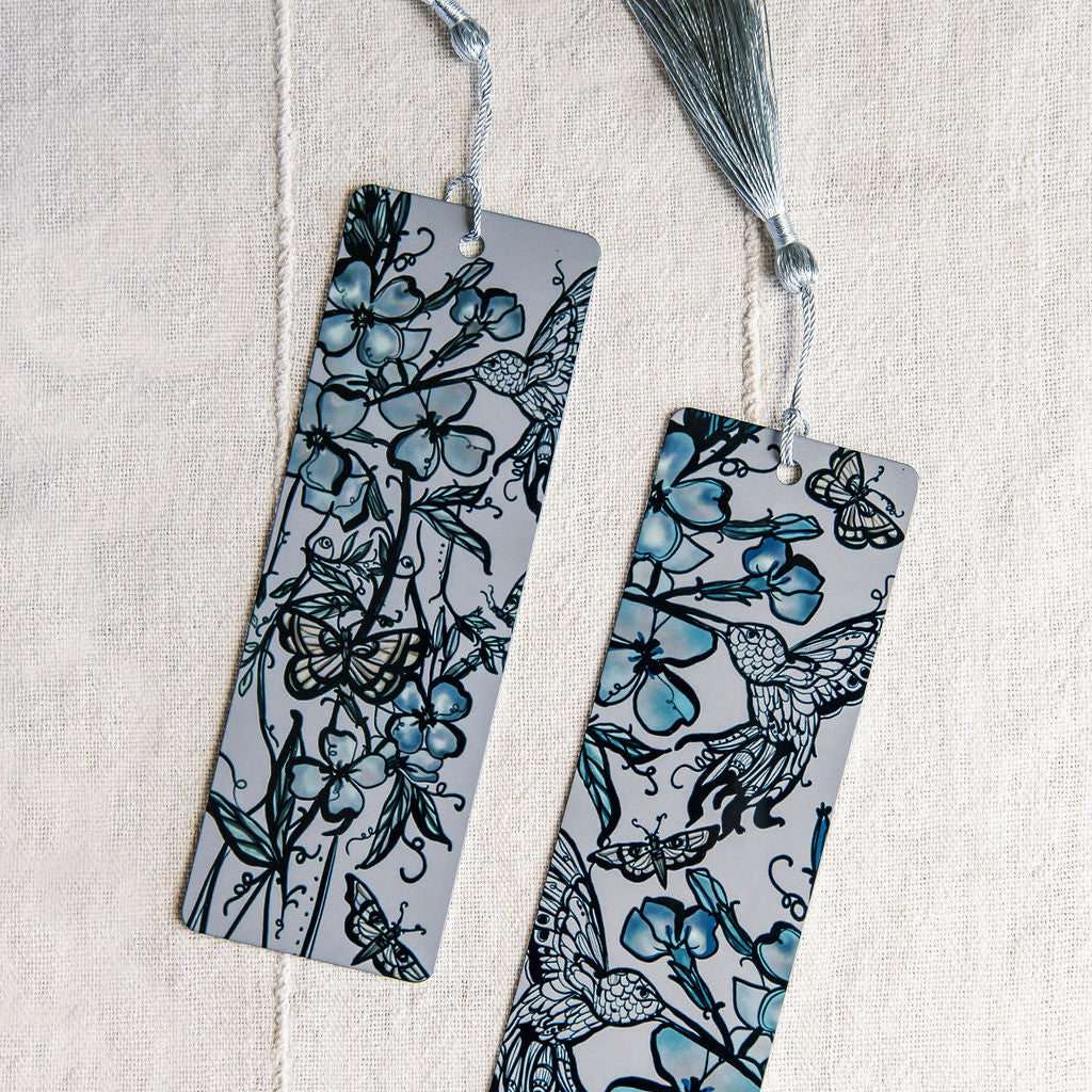 two metal bookmarks with hummingbird and botanical feminine figure by Marcy Ellis. 