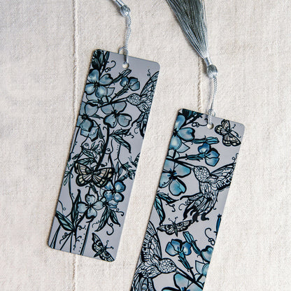 two metal bookmarks with hummingbird and botanical feminine figure by Marcy Ellis. 