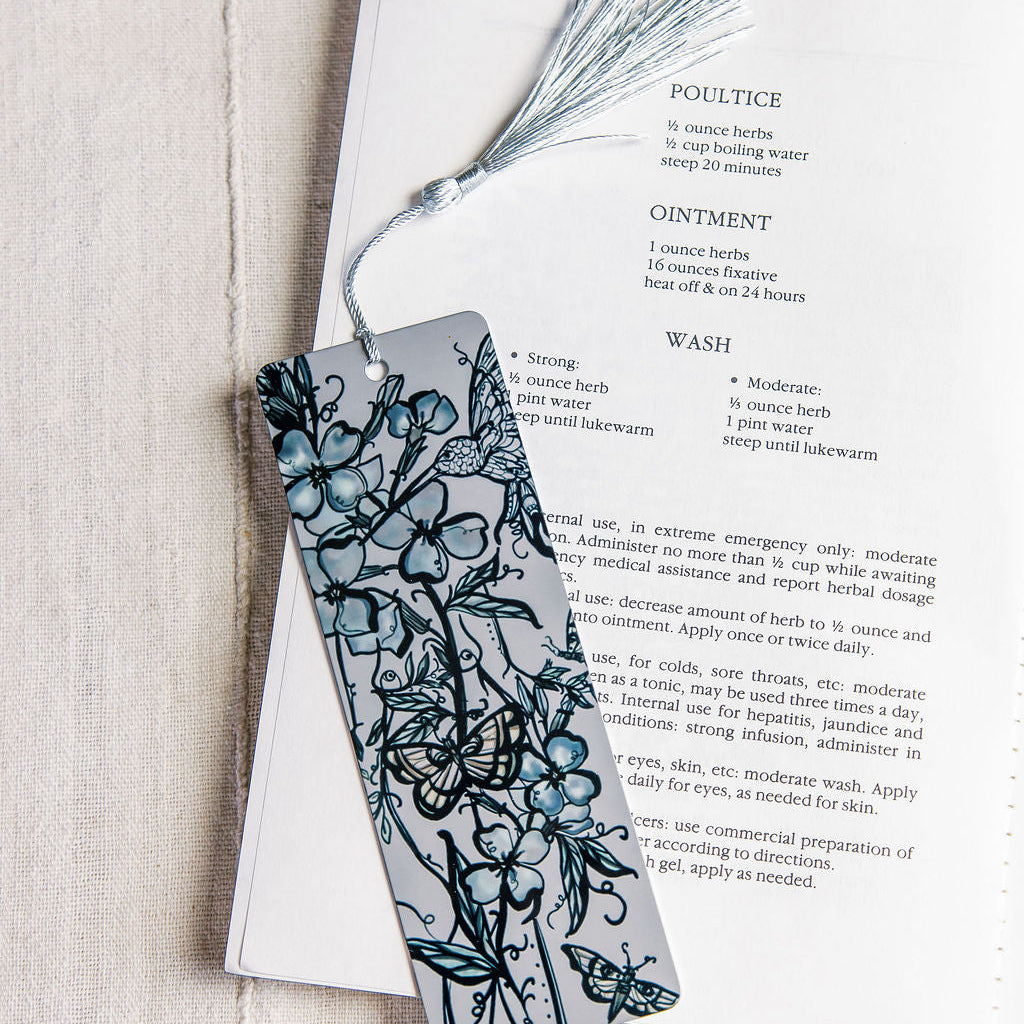 metal bookmark with flue flowers and a botanical figure with butterflies by Marcy Ellis.. 