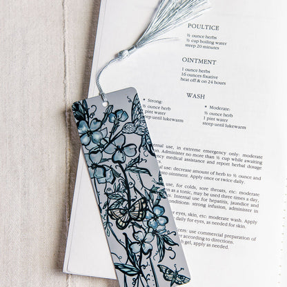 metal bookmark with flue flowers and a botanical figure with butterflies by Marcy Ellis.. 