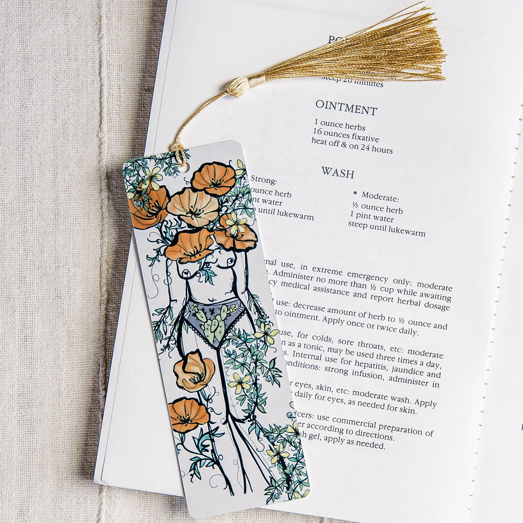 a metal bookmark with a desert botanical feminine figure by Marcy Ellis. 