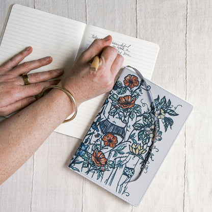 a5 lined journal with watercolor feminine botanical figures wrapping the front and back covers. 190 pages, faux leather cover. hand-painted design by artist Marcy Ellis in Tucson, AZ.