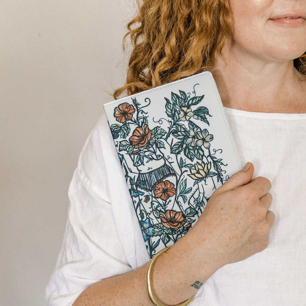a5 lined journal with watercolor feminine botanical figures wrapping the front and back covers. 190 pages, faux leather cover. hand-painted design by artist Marcy Ellis in Tucson, AZ.