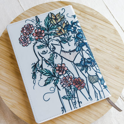 a5 lined journal with watercolor feminine botanical figures wrapping the front and back covers. 190 pages, faux leather cover. hand-painted design by artist Marcy Ellis in Tucson, AZ.