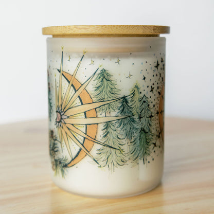 bamboo lid on yule winter solstice soy candle with botanical artwork wrapped around frosted glass jar