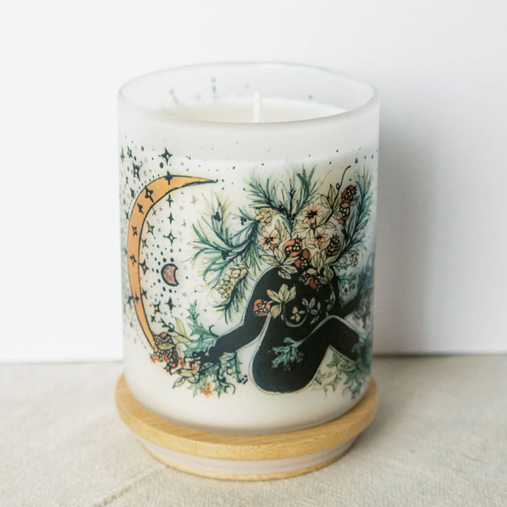 yule winter solstice soy candle with botanical artwork wrapped around frosted glass jar