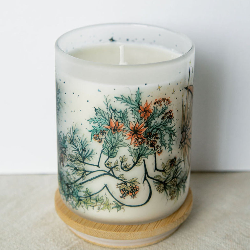 yule winter solstice soy candle with botanical artwork wrapped around frosted glass jar
