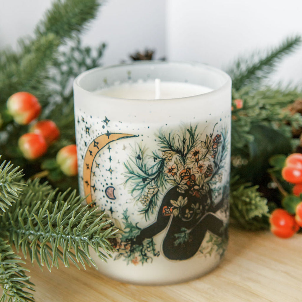 yule winter solstice soy candle with botanical artwork wrapped around frosted glass jar