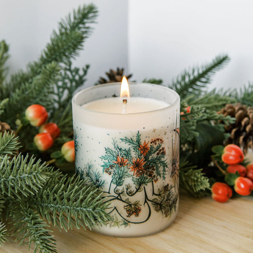 yule winter solstice soy candle with botanical artwork wrapped around frosted glass jar