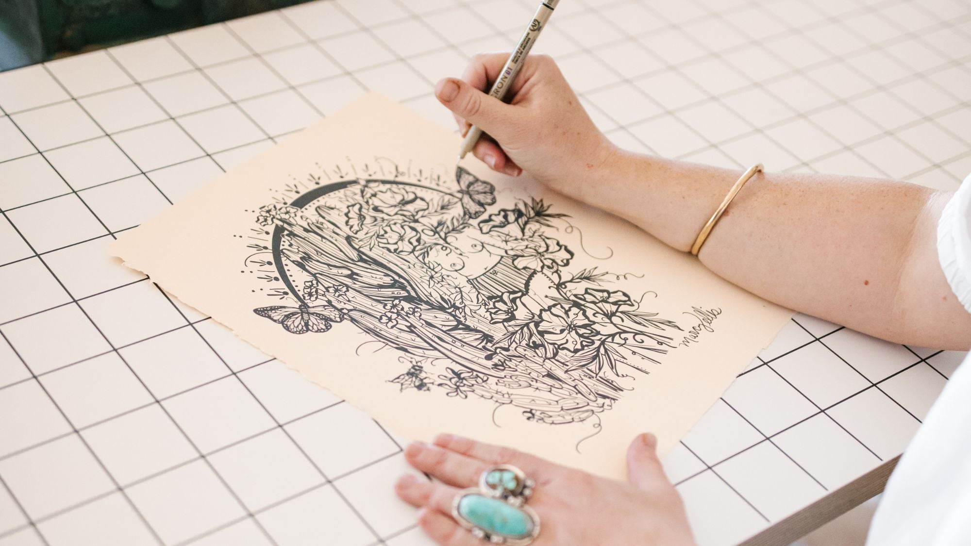 Marcy Ellis drawing a botanical feminine figure with ink Tucson Arizona 